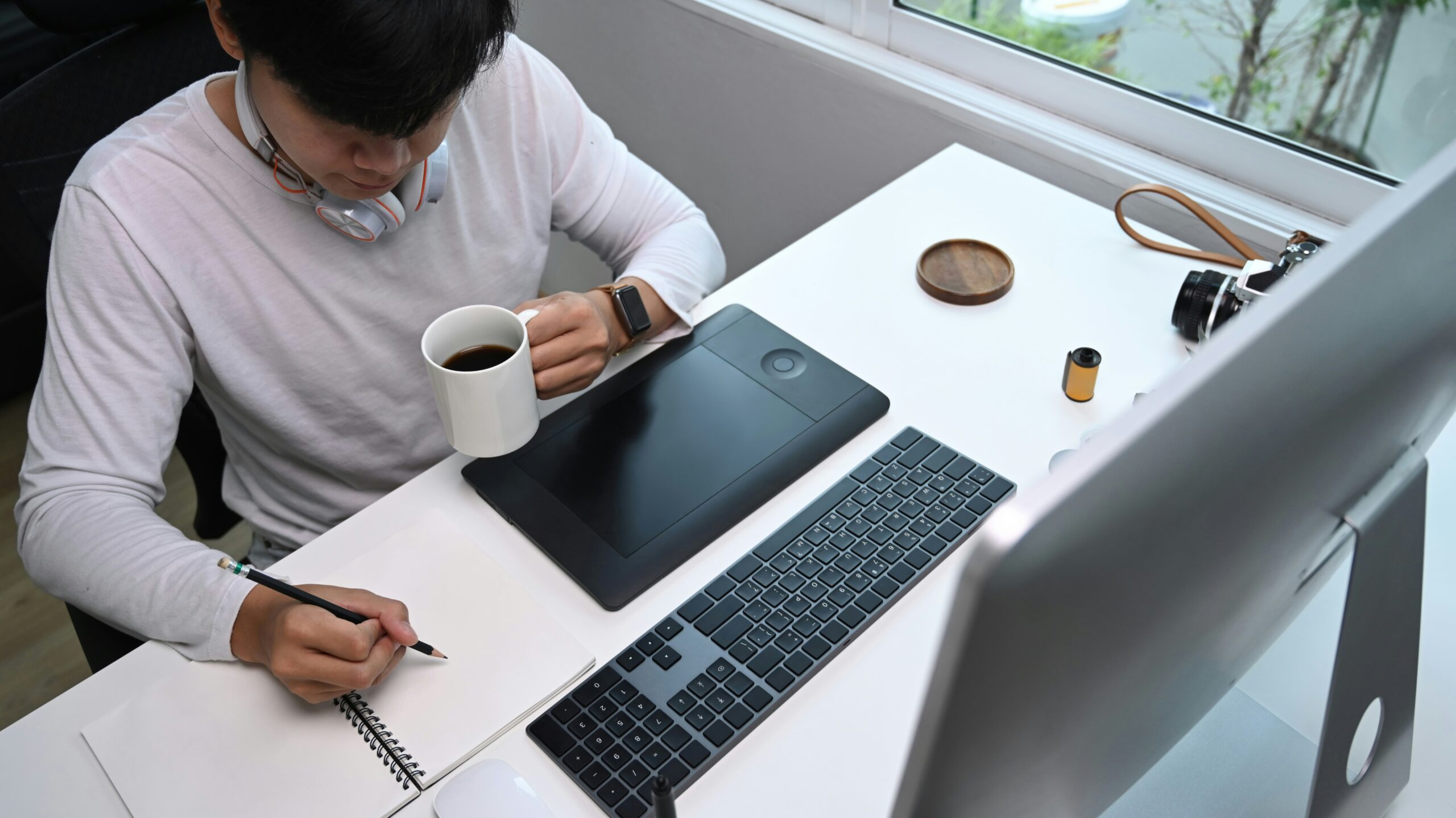 A small business owner sitting at a desk with organized folders, a laptop showing a simple P&L chart, and a coffee mug nearby.